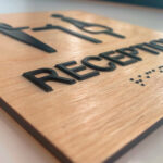 Taktiles Schild aus Holz mit Braille-Schrift
